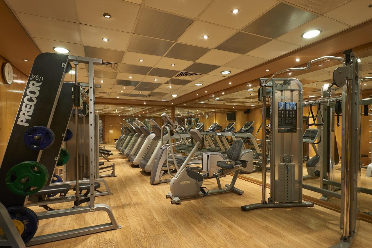 Safir Hotel Cairo Giza Exterior photo The photo shows a well-equipped gym with various exercise machines. There are several cardio machines lined up, including treadmills, stationary bikes, and elliptical trainers. Strength training equipment is also present, including a multi-functional